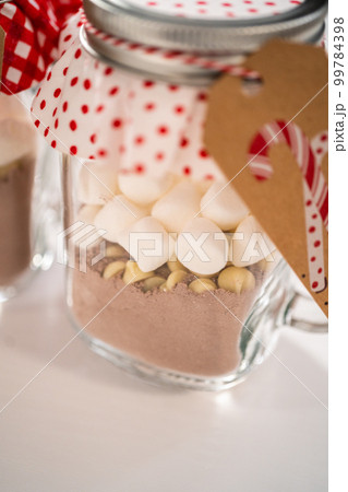Making homemade hot chocolate mix in drinking mason jar for Christmas food gift. Making homemade hot chocolate mix in drinking mason jar for Christmas food gift. 99784398