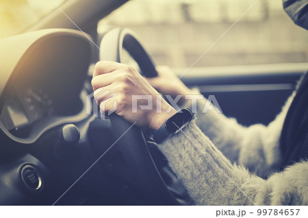 車を運転する女性の手元 99784657