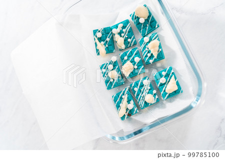 Packaging mini mermaid chocolate bars into a food glass container for storage. Packaging mini mermaid chocolate bars into a food glass container for storage. 99785100