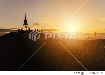 The beautiful sunset and the silhouette of tourist on the summit of Mt.Eden an iconic volcano in Auckland, New Zealand. 99787834