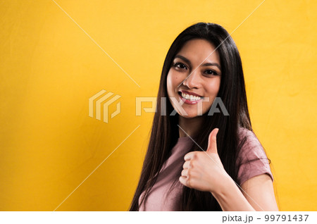 Young pretty woman makes thumb-up gesture 99791437