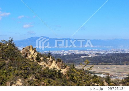 湖南アルプスの堂山の巨岩ごしに見る大津市街と比叡山 99795124