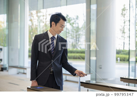 オフィスビルのセキュリティゲートを通るビジネスマン 99795347