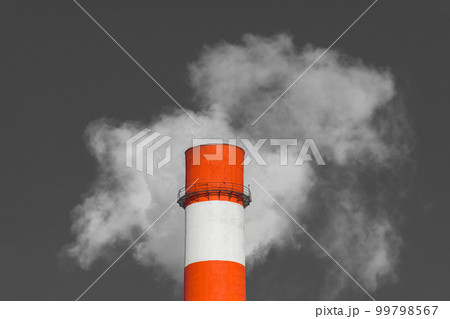 Pollution of the environment, ecology and air. Withdrawal of combustion products of soot, smoke and gases from the pipe of an industrial plant into the atmosphere against the background of a gray sky Pollution of the environment, ecology and air. Withdrawal of combustion products of soot, smoke and gases from the pipe of an industrial plant into the atmosphere against the background of a gray sky 99798567