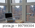 ノートパソコンと本のあるNYのアパートと都会の景色 99799304