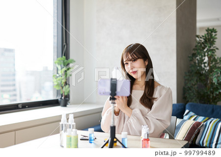 ライブ配信で化粧品の販売をする女性 99799489