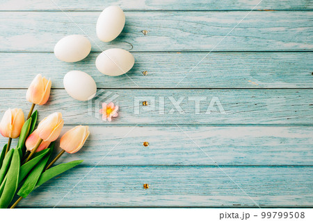 Happy Easter Day Concept. Top view of holiday banner background design white easter eggs and spring tulip flowers on blue wooden background with empty copy space, celebration greeting card 99799508