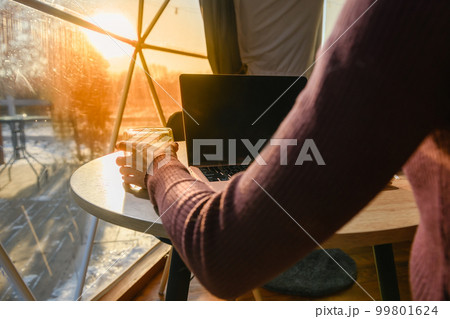 View from the back of a girl sitting at a table by the window View from the back of a girl sitting at a table by the window 99801624