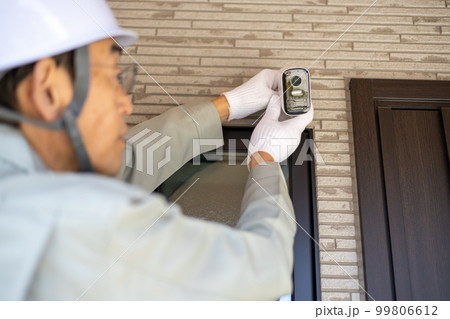一戸建て住宅の外壁に防犯カメラを取り付けようとしているところ 一戸建て住宅の外壁に防犯カメラを取り付けようとしているところ 99806612