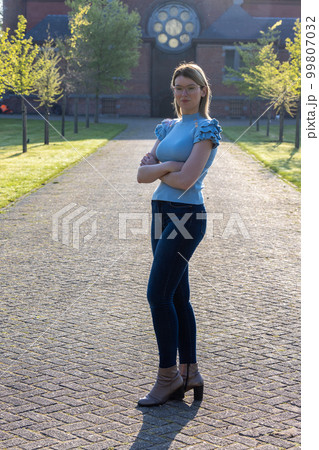 full body sunrise portrait of attractive woman looking at the camera and sun in back light. Enjoying full body sunrise portrait of attractive woman looking at the camera and sun in back light. Enjoying 99807032