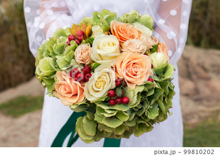 The bride holds a beautiful bouquet of roses on her wedding day. Floristics and decor, wedding organization 99810202