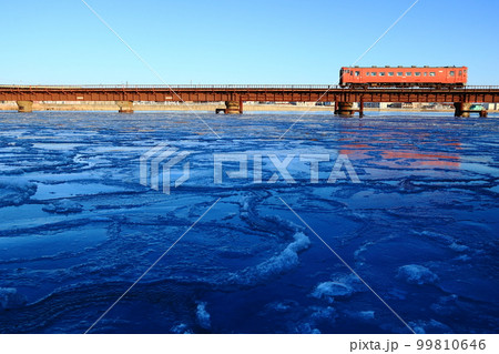 釧網本線釧路川橋梁　蓮の葉氷の川面に写してたらこ色のキハ40単行気動車が行く　根室本線 99810646
