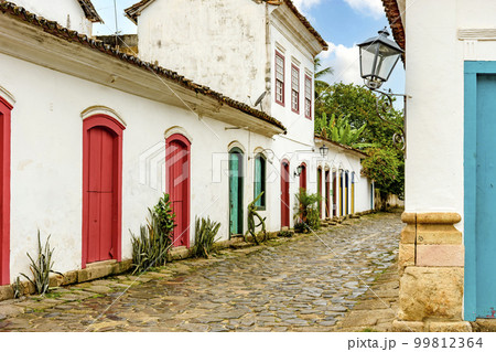 Street with cobblestone pavement and facades of old colonial houses 99812364