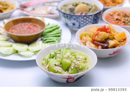 stir-fried zucchini with eggs in a white dish in a bowl on the set of group plates Thai food. Top view. vertical view 99813393