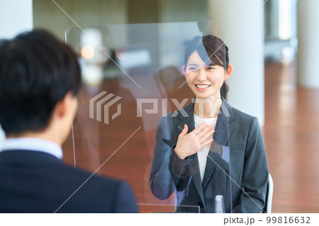 感染症対策された会場で面接を受ける就活中の若いビジネスウーマン 感染症対策された会場で面接を受ける就活中の若いビジネスウーマン 99816632