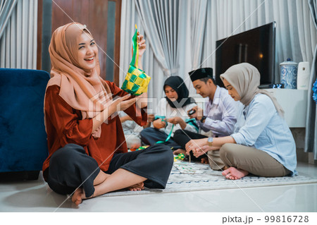 attractive veiled woman holding woven ketupat ornaments for Eid decoration attractive veiled woman holding woven ketupat ornaments for Eid decoration 99816728