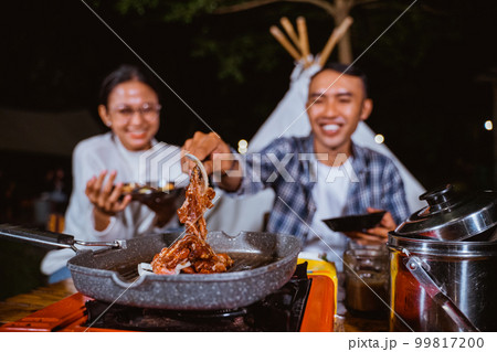 the guy in plaid shirt taking the grilled beef the guy in plaid shirt taking the grilled beef 99817200