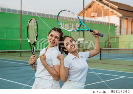 two happy female tennis players with fists clenched during celebration two happy female tennis players with fists clenched during celebration 99817249