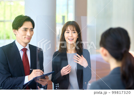 感染症対策された会場で面接する男女ビジネスパーソン 99817320