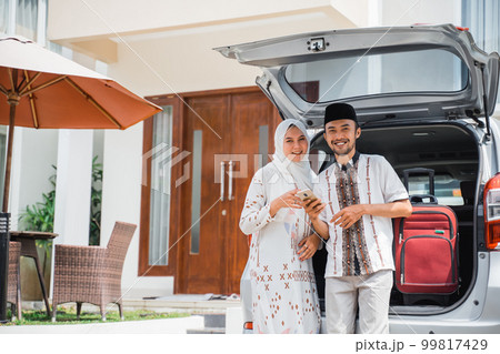 Asian Muslim couple smiling preparing to go mudik 99817429