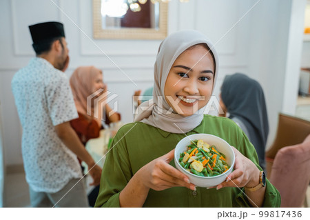 muslim woman with food served for family and friend for dinner muslim woman with food served for family and friend for dinner 99817436