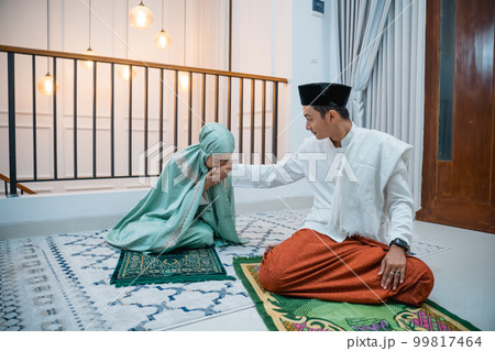 woman kisses man's hand as prayer leader after praying woman kisses man's hand as prayer leader after praying 99817464