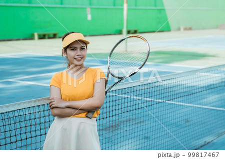 female tennis player smiling at camera with crossed hands 99817467
