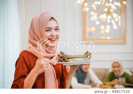 Beautiful veiled girl carrying a plate of food 99817520