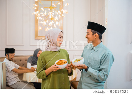 husband and wife serving food for friend and family for break fasting 99817523
