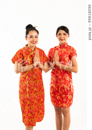 two young wowoman men in cheongsam standing together with hands put together two young wowoman men in cheongsam standing together with hands put together 99818090