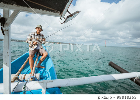 smiling angler sitting on the end of a fishing boat 99818265