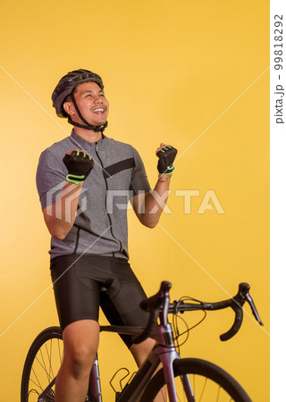 happy asian man sitting on the bicycle with clenched arms 99818292