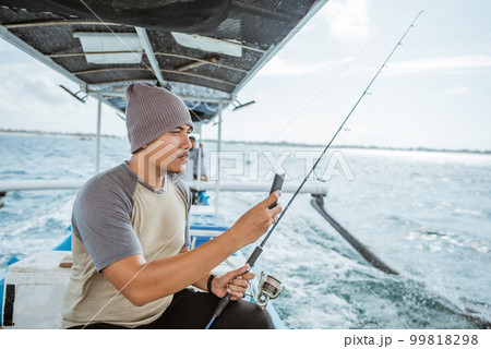 fisherman takes a cell phone photo of the situation around 99818298