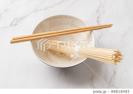 Dried udon nudles in a bowl closeup. 99818485