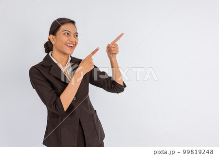 asian woman in formal outfit looking up and pointing with her finger 99819248