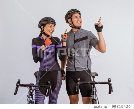 asian couple in cycling outfit looking up and pointing with their finger 99819426