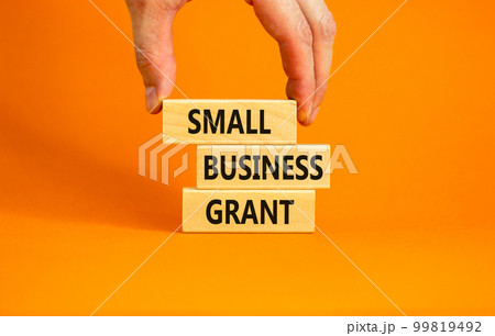 Small business grant symbol. Concept words Small business grant on wooden blocks on a beautiful orange table orange background. Businessman hand. Business, finacial and small business grant concept. Small business grant symbol. Concept words Small business grant on wooden blocks on a beautiful orange table orange background. Businessman hand. Business, finacial and small business grant concept. 99819492