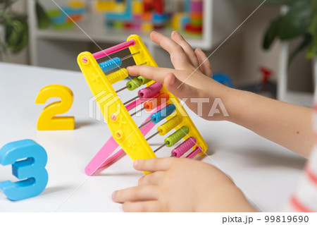 A small child learns to count on abacus, mathematics, arithmetic for children. A small child learns to count on abacus, mathematics, arithmetic for children. 99819690