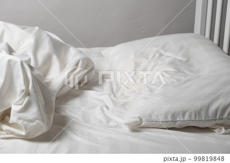 Unmade bed, satin white linen, white bed, pillow and blanket Unmade bed, satin white linen, white bed, pillow and blanket 99819848
