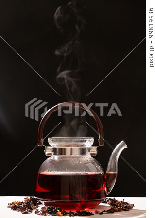Red hibiscus tea from the petals of a Sudanese rose in a glass teapot, place for the text 99819936