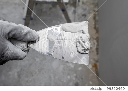 Plasterer applies plaster on the wall during repair and restoration work Plasterer applies plaster on the wall during repair and restoration work 99820460