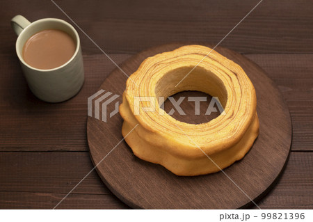 Top view of baumkuchen, sakotis ,sekacz on brown wooden table, delicious homemade traditional spit cake with a cup of coffee. Horizontal plane, flatly 99821396