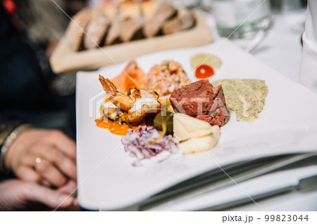 Restaurant concept, appetizer consisting of grilled shrimp, tartare, sauce, onion, tomato, lettuce Restaurant concept, appetizer consisting of grilled shrimp, tartare, sauce, onion, tomato, lettuce 99823044
