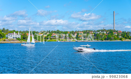 Sailboat and a motorboat by the shore of the Swedish Archipelago on a sunny day 99823068