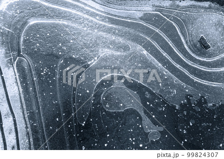 Textured ice background with white snow curves on the surface, and an air bulb in the shape of a whale. The photo showcases the beauty and intricacy of nature's designs in a winter landscape. High Textured ice background with white snow curves on the surface, and an air bulb in the shape of a whale. The photo showcases the beauty and intricacy of nature's designs in a winter landscape. High 99824307