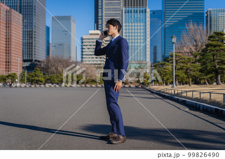 スマホで会話しているビジネスマン スマホで会話しているビジネスマン 99826490
