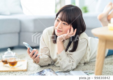 女性 リラックス スマホ ティータイム 読書 紅茶 ライフスタイル リビング 女性 リラックス スマホ ティータイム 読書 紅茶 ライフスタイル リビング 99830842