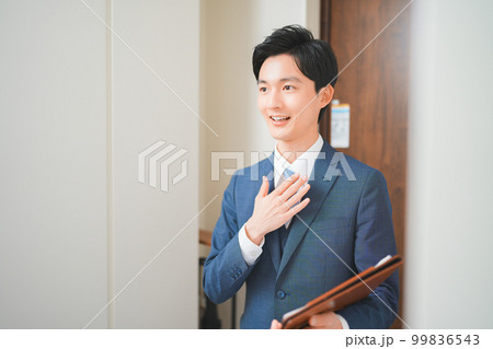 訪問販売をする若いビジネスマンの男性 99836543