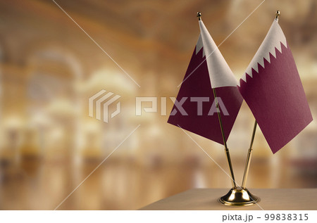 Small flags of the Qatar on an abstract blurry background 99838315