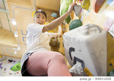 ボルダリングをする若い女性 99841008